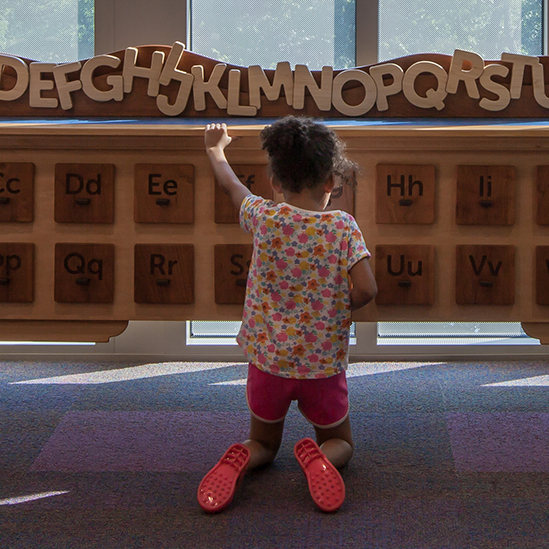 girl playing with a card catalog exhibit